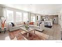 Spacious living room with plush sofas and abundant natural light, seamlessly connected to the dining area and kitchen at 4312 Gypsum Ave, Mead, CO 80504