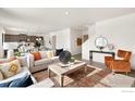 Bright and airy living room featuring modern decor, a cozy seating area, and an open layout to the kitchen at 4312 Gypsum Ave, Mead, CO 80504