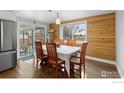 Bright dining area with wood-paneled accent wall and a sliding door to the backyard at 6260 W 61St Ave, Arvada, CO 80003