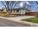 Well-kept exterior with inviting yellow front door, basketball hoop, and mature landscaping at 6260 W 61St Ave, Arvada, CO 80003