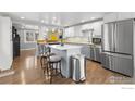 Open kitchen featuring a center island, stainless steel appliances, and breakfast bar seating at 6260 W 61St Ave, Arvada, CO 80003