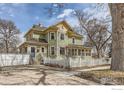 Charming two-story home with a white picket fence and inviting curb appeal at 705 7Th St, Berthoud, CO 80513