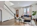 Inviting living room showcasing hardwood floors, staircase, large windows, and stylish decor at 718 25Th St, Denver, CO 80205