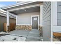 Covered front porch featuring stone pillars, a neutral color palette, and a welcoming entryway at 786 Griffith St, Lochbuie, CO 80603