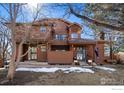 Two-story townhouse with brown siding and steps leading to the front porch at 8015 Holland Ct # A, Arvada, CO 80005