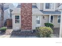 Charming townhome exterior with well-kept landscaping and a classic brick chimney under a bright, sunny sky at 8300 W 87Th Dr # B, Arvada, CO 80005