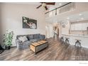 Open-concept living room with hardwood floors, comfortable seating and staircase at 13421 Humboldt Way, Thornton, CO 80241