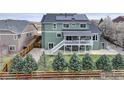 The backyard features a spacious deck, well-kept lawn, and a charming wooden fence at 1348 Lawson Ave, Erie, CO 80516