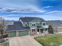 Beautiful green home boasts a three-car garage, well-maintained lawn, and a charming front porch at 1348 Lawson Ave, Erie, CO 80516