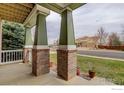 The cozy front porch features brick columns and offers a welcoming outdoor space at 1348 Lawson Ave, Erie, CO 80516