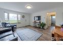 Inviting living room with wood floors, white walls, and a view of the front door and hallway at 1630 Calkins Ave, Longmont, CO 80501