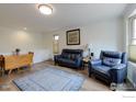 Bright living area featuring hardwood floors, a bay window, and comfortable blue seating at 1630 Calkins Ave, Longmont, CO 80501