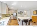 Well-lit kitchen featuring an island with seating, stainless steel appliances, light colored cabinetry, and hardwood floors at 1709 Alpine Ave # 6, Boulder, CO 80304