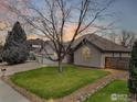 Inviting home exterior with a manicured lawn, mature trees, and elegant architectural details at 1730 Crestone Dr, Longmont, CO 80504