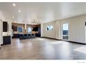 Spacious living room with hardwood floors, modern lighting, and an open floor plan to the kitchen at 1778 Peak Loop, Broomfield, CO 80023