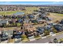 An aerial view of a neighborhood that shows a golf course, homes, and a beautiful blue sky at 1788 Alpine Dr, Erie, CO 80516