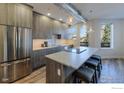 Modern kitchen with stainless steel appliances, a center island with seating, and ample counter space at 2850 E College Ave # 105, Boulder, CO 80303