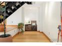 Hallway with hardwood floors and stairs leading to an upper level at 2937 Champa St # A, Denver, CO 80205