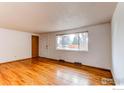 Bright, open living room featuring hardwood floors, white walls, and a large window providing ample natural light at 312 Buckley Dr, Longmont, CO 80501
