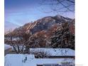 Winter mountain views from a snow-covered house featuring trees and beautiful skies at 3265 6Th St, Boulder, CO 80304