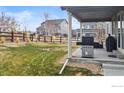 Fenced backyard featuring a covered patio with grill, seating and grassy area at 4621 Prairie River Ct, Longmont, CO 80504