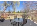 Outdoor patio area perfect for entertaining, with a view of the expansive backyard and mature trees at 4940 Carter Ct, Boulder, CO 80301