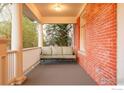 Inviting covered front porch features a comfortable outdoor seating area and classic brick accents at 720 Mapleton Ave, Boulder, CO 80304
