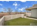 Spacious backyard featuring lush artificial turf and a classic white picket fence, perfect for relaxation at 9266 W 107Th Ln, Broomfield, CO 80021