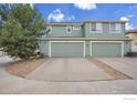 Two-car garage with light green doors and plenty of parking space, complemented by decorative gravel landscaping at 9266 W 107Th Ln, Broomfield, CO 80021