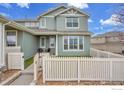 Two-story home featuring light green siding, a well-manicured front yard, and a charming white picket fence at 9266 W 107Th Ln, Broomfield, CO 80021