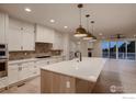 Bright, spacious kitchen with white cabinets, stainless steel appliances, and large island at 935 Eldorado Ln # A, Louisville, CO 80027