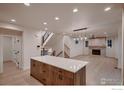 Spacious kitchen with an eat-in island overlooks the modern living room with fireplace and staircase at 935 Eldorado Ln # A, Louisville, CO 80027