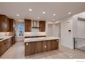 Bright kitchen with modern wood cabinets, stainless steel appliances, a large island, and contemporary backsplash at 935 Eldorado Ln # A, Louisville, CO 80027