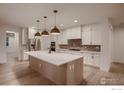 Modern kitchen boasts white cabinets, a large island, and stainless-steel appliances at 935 Eldorado Ln # A, Louisville, CO 80027