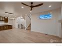 Open concept living room boasts hardwood floors, statement ceiling fan, modern staircase, and lots of natural light at 935 Eldorado Ln # A, Louisville, CO 80027