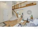 Bright living room with hardwood floors, staircase, and view into dining area at 1080 Stoneham St, Superior, CO 80027