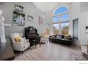 Bright living room boasts large windows, wood floors, and decoratively arranged furniture and artwork at 11270 W 66Th Pl, Arvada, CO 80004