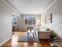 Bright living room featuring hardwood floors, neutral color palette, and window to dining area at 1130 N Pennsylvania St # 306, Denver, CO 80203