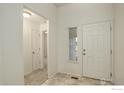 Bright entryway featuring neutral flooring, white walls, and an adjacent hallway leading to other rooms at 1540 Murrlet St, Berthoud, CO 80513