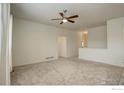 Spacious living room featuring plush carpeting, neutral paint, a ceiling fan, and abundant natural light at 1540 Murrlet St, Berthoud, CO 80513