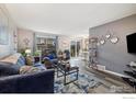 Open-concept living room flows into dining area with stylish decor and updated flooring at 1561 S Sheridan Blvd, Lakewood, CO 80232