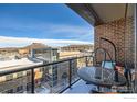 Cozy balcony with an outdoor lounge chair offering city views, brickwork, and a clear glass barrier at 20 Wilcox St # 518, Castle Rock, CO 80104