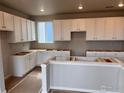 Spacious kitchen with white cabinets, ample counter space, and natural light at 2261 Peregrine Dr, Brighton, CO 80601