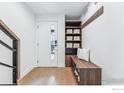 Clean entryway with a built-in storage bench, coat rack and a bright front door at 2471 Walnut St, Boulder, CO 80302