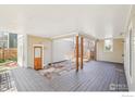 Large back porch features wood flooring, wood pillars, and an area of embedded stones at 2607 Thornbird Pl, Boulder, CO 80304
