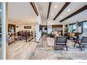 Bright, open-concept living space featuring hardwood floors, beamed ceilings, and seamless flow to the dining area at 274 Boulder View Rd, Boulder, CO 80302