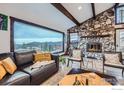 Cozy living room with a stone fireplace, beamed ceilings, and a large window showcasing mountain vistas at 274 Boulder View Rd, Boulder, CO 80302