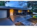 Well-lit exterior featuring a brick facade, front patio, and attached garage at 3282 4Th St, Boulder, CO 80304