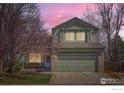 Charming two-story home with a well-maintained lawn and colorful trees in full bloom at 3469 Larkspur Dr, Longmont, CO 80503