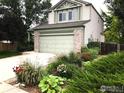 View of the two-story home's lush landscaping and well-maintained lawn at 3469 Larkspur Dr, Longmont, CO 80503